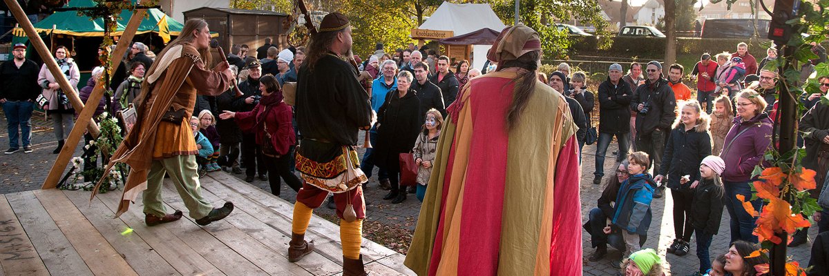 Bühne auf den Märchen- und Sagentagen Älterer Mann in mittelalterlichen Klamotten arbeitet an einem Amboss