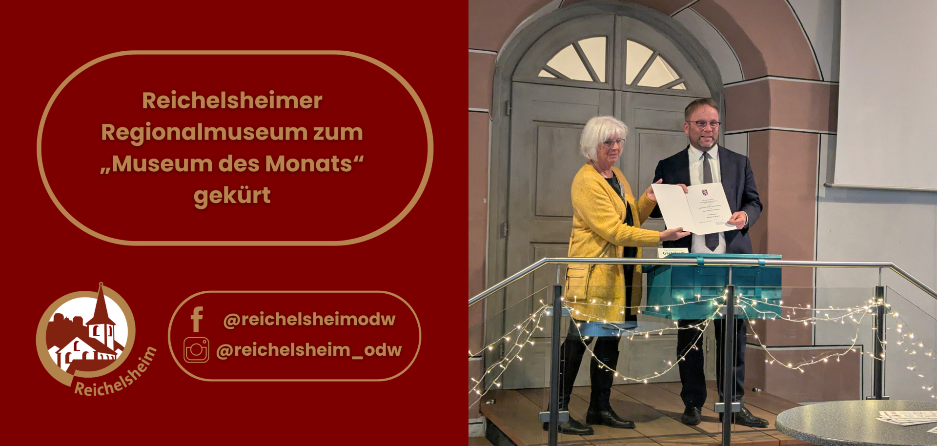 Die linke Hälfte ist ein roter Bereich mit goldfarbenen Rändern und Text. Der Haupttext in der oberen Hälfte lautet: „Reichelsheimer Regionalmuseum zum „Museum des Monats“ gekürt“. Unten links befindet sich ein rundes Logo mit der Silhouette eines Gebäudes (vermutlich das Museum oder eine Kirche) und dem Schriftzug „Reichelsheim“. Rechts davon sind Social-Media-Icons (Facebook und Instagram) mit den Benutzernamen "@reichelsheimodw" und "@reichelsheim_odw" zu sehen.  Die rechte Hälfte zeigt eine Szene in einem Innenraum. Eine Frau mit kurzen, hellen Haaren und einem gelben Cardigan steht neben einem Mann im dunklen Anzug mit Brille. Sie halten gemeinsam eine weiße Urkunde oder ein Zertifikat. Hinter ihnen ist eine große, holzgetäfelte Doppeltür mit einem Bogenfenster zu sehen. Im Vordergrund verläuft ein Geländer, das mit mehreren Lichterketten geschmückt ist. Die Szene vermittelt den Eindruck einer offiziellen Übergabe oder Feierlichkeit.