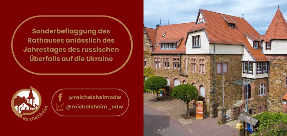Blick auf das steinerne Rathaus von Reichelsheim mit rotem Dach. Links die Ankündigung zur Sonderbeflaggung am Jahrestag des russischen Überfalls auf die Ukraine.